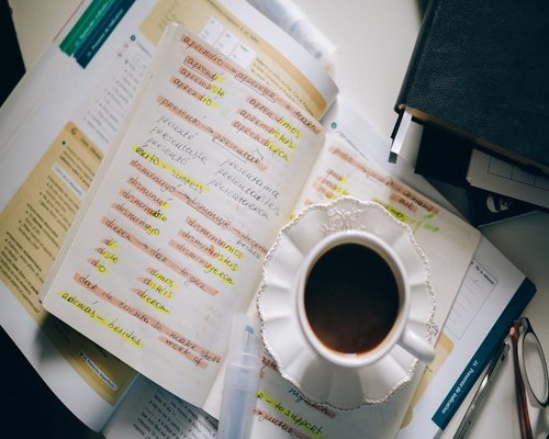 A cup of coffee next to a notebook with handwritten notes in a cafe in Providencia